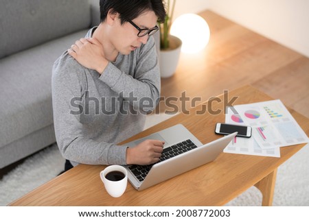 Man opens a laptop and works in the living room of the house Royalty-Free Stock Photo #2008772003