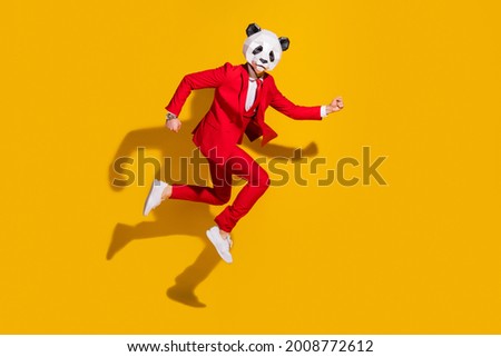 Photo of funky hurry panda guy jump hurry late wear mask red tuxedo sneakers isolated on yellow color background