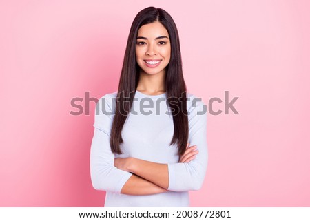Photo portrait of girl with crossed hands in blue shirt smiling happy isolated on pastel pink color background