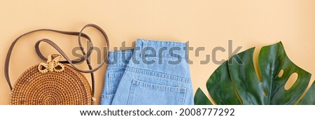 Summer composition with female fashion outfit. Monstera leaves, bamboo bag, shoes on pastel orange background. Flat lay, top view, overhead, mockup, template, copy space