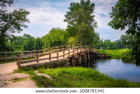 Old North Bridge at Minute Man National Historical Park in Concord, Massachusetts. Tranquil Nature Landscape with Landmark Bridge and Clean River. Peaceful American New England Image. Royalty-Free Stock Photo #2008781345