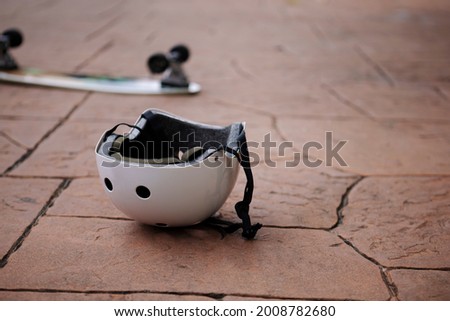 Skateboard and protective helmet on a floor , Safety concept