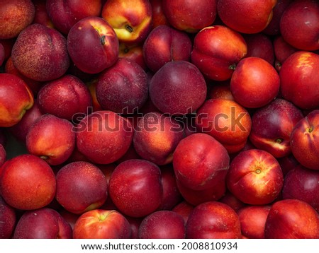 Background of bright and ripe nectarines in full screen. Autumn wallpaper of exotic southern fruits. The concept of harvesting. Royalty-Free Stock Photo #2008810934