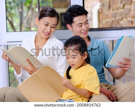 A happy family of three reading on the sofa high quality photo