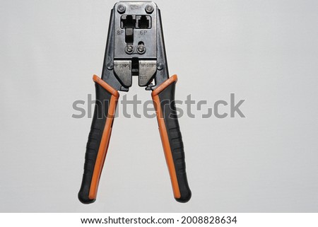 Crimping pliers for network installation work commonly used by technicians in the field of information technology. Crimping pliers with orange handle on white background. Royalty-Free Stock Photo #2008828634