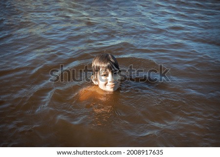 Head of boy above water, swimming in muddy river, sea or lake Royalty-Free Stock Photo #2008917635