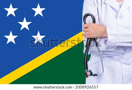 Female doctor with stethoscope in hand on the background of the Solomon islands flag. Concept medicine, pandemic in the country