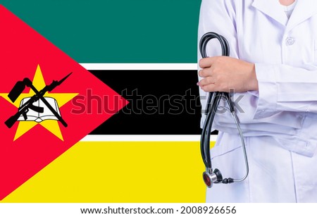 Female doctor with stethoscope in hand on the background of the Mozambique flag. Concept medicine, pandemic in the country