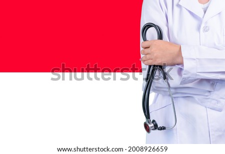 Female doctor with stethoscope in hand on the background of the Monaco flag. Concept medicine, pandemic in the country