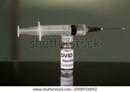 Vaccination against coronavirus. Ampoule with a vaccine and a syringe for injection. Close-up shot.