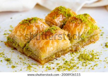 Pistachio baklava on a white wooden background. Baklava on a marble floor. Close up Royalty-Free Stock Photo #2008936115