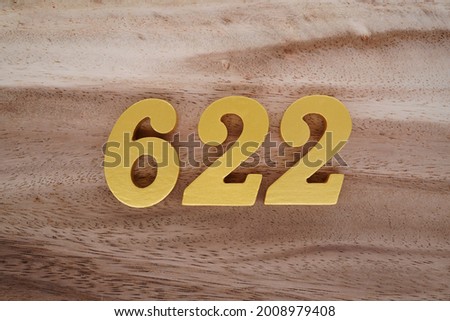 Gold numerals 622 on a dark brown to off-white wood pattern background.
