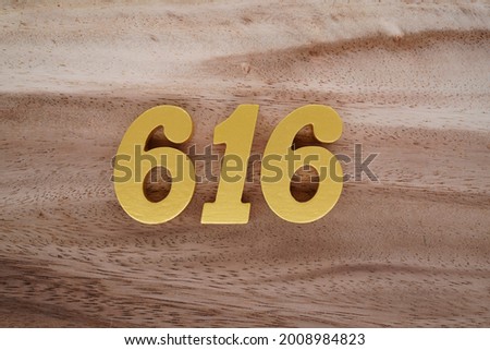 Gold numerals 616 on a dark brown to off-white wood pattern background.