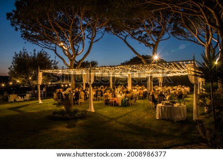 Marquee lit  at night in a  traditional  wedding in Italy, summer 2021. Garden  party in the open Royalty-Free Stock Photo #2008986377