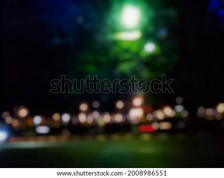 defocused abstract background of the night scene illuminated by the headlights of vethicles on the highway