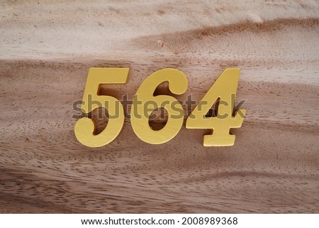 Gold numerals 564 on a dark brown to off-white wood pattern background.