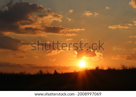 Beautiful sunset on background of cloudy sky at dusk in summer
