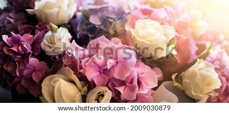 A festive bouquet of a bouquet of roses and hydrangeas in the rays of sunlight. Flower background