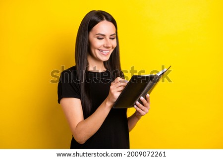 Photo of pretty satisfied person toothy smile hands hold notebook pencil isolated on yellow color background