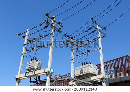 Large high voltage transformer It is installed on strong concrete poles to supply electricity to the buildings with the background of the sky. Royalty-Free Stock Photo #2009112140