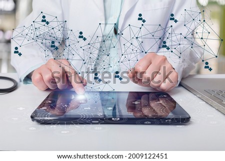The doctor works in the network on a tablet computer he is at the table.