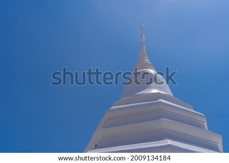 closeup ancient white pagoda or chedi with clear bright blue sky at Wat Pa Lelai Worawihan temple, travel attraction at Suphanburi, Thailand