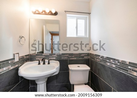 Small powder room interior with black and white tiles Royalty-Free Stock Photo #2009156309
