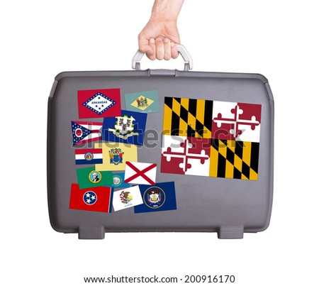 Used plastic suitcase with stains and scratches, stickers of US States, Maryland