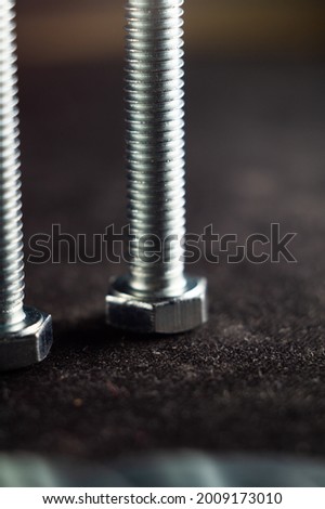 A vertical closeup shot of long textured metallic screws