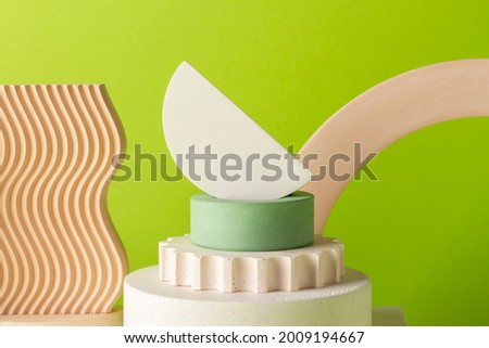 Composition of plaster decorations of different geometries on a lime green background.