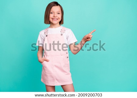 Photo of charming nice pretty small girl point finger empty space sale news isolated on teal color background