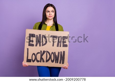 Photo of depressed sad lady dressed green clothes holding end lockdown placard looking empty space isolated purple color background