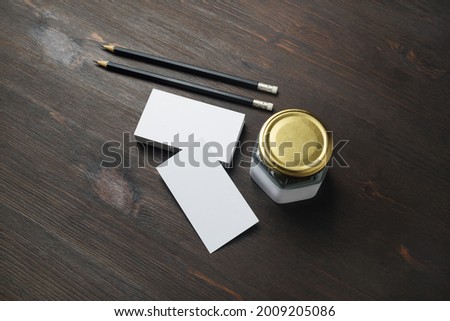 Blank business cards, pencils and jar on wooden background. ID mockup. Responsive design template.