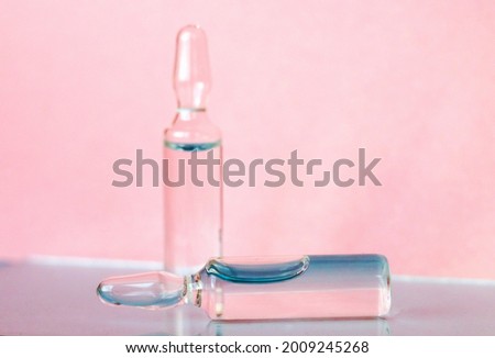 Ampoules for medical and cosmetic products on a pink background. Substance solution for injection
