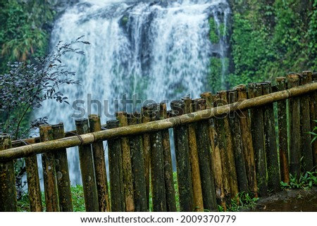 old bamboo fence next to the waterfall