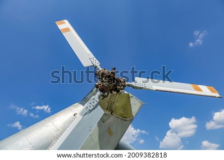 Powerful propeller and blades of a military helicopter against the background of a bright blue sky
