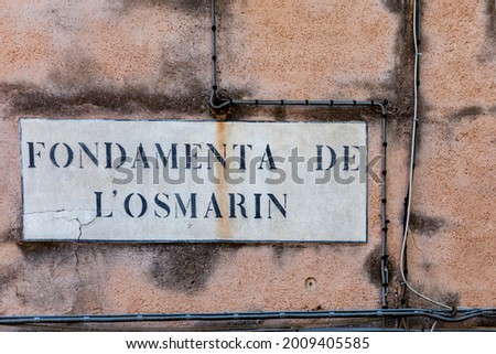 signage Fondamenta L'Osmarin - english: quay of Osmarin - in Venice at an old grunge house wall