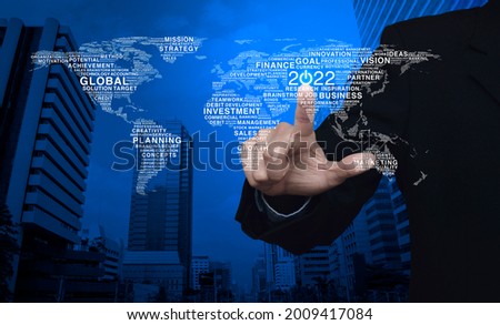 Businessman pressing 2022 start up business icon with global words world map over city tower and skyscraper, Happy new year 2022 business start up concept, Elements of this image furnished by NASA