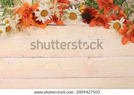 Abstract floral composition with place for text, still life, autumn banner, lilies and chamomile on a wooden background. Mother's day card, womens day, valentine's day, happy birthday, wedding, select