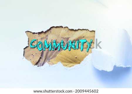 Text caption presenting Community. Conceptual photo group of showing with a common characteristics living together Tear on sheet reveals background behind the front side