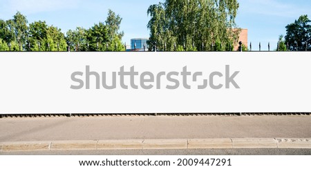 Advertising empty long white billboard with space for mockup information at urban street front view Royalty-Free Stock Photo #2009447291