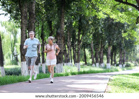 Old couple jogging in outdoor park high quality photo
