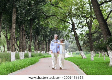 Happy old couple walking in the park high quality photo