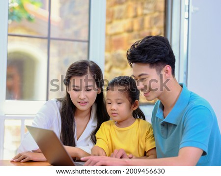 Happy family of three using laptop high quality photo