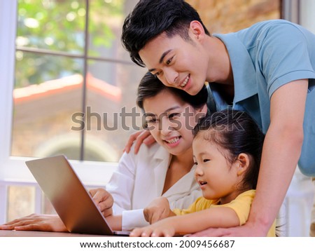 Happy family of three using laptop high quality photo
