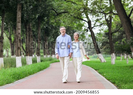 Happy old couple walking in the park high quality photo