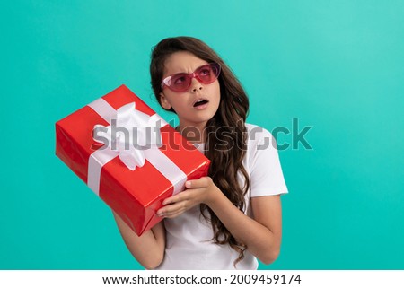 fashionable curious kid in sunglasses hold gift box, curiosity
