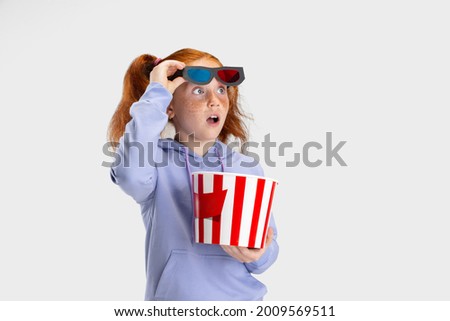 Watching 3d movie. Portrait of cute freckled red-headed girl in casual outfit isolated on white studio background. Happy childhood concept. Sunny child. Emotions, facial expression concept