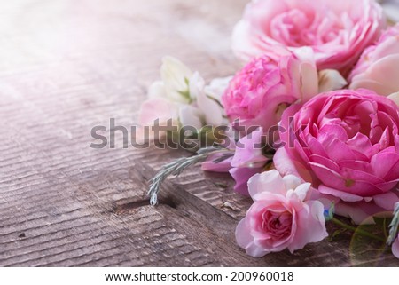 Postcard with fresh flowers on aged wooden background.