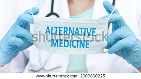 doctor's hands are holding a disposable mask with the inscription Alternative medicine